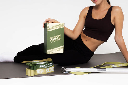 Woman with Tribe Lifting long loop resistance bands set, handles, and workout accessories