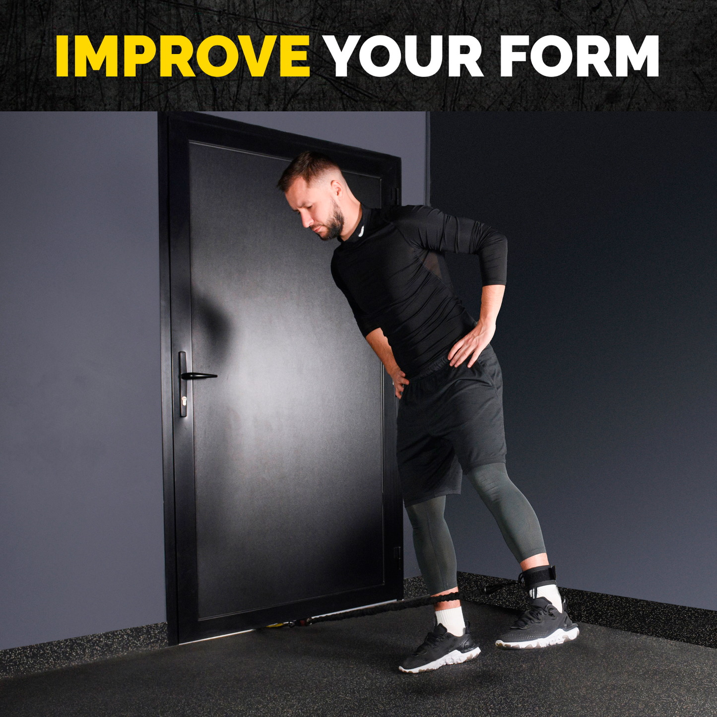 Man using a Tribe Lifting padded ankle strap for a standing hip abduction exercise with resistance attached at ankle height