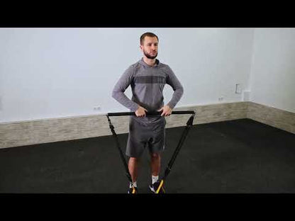 Man using a foam-padded Pilates resistance bar with resistance bands during a standing workout