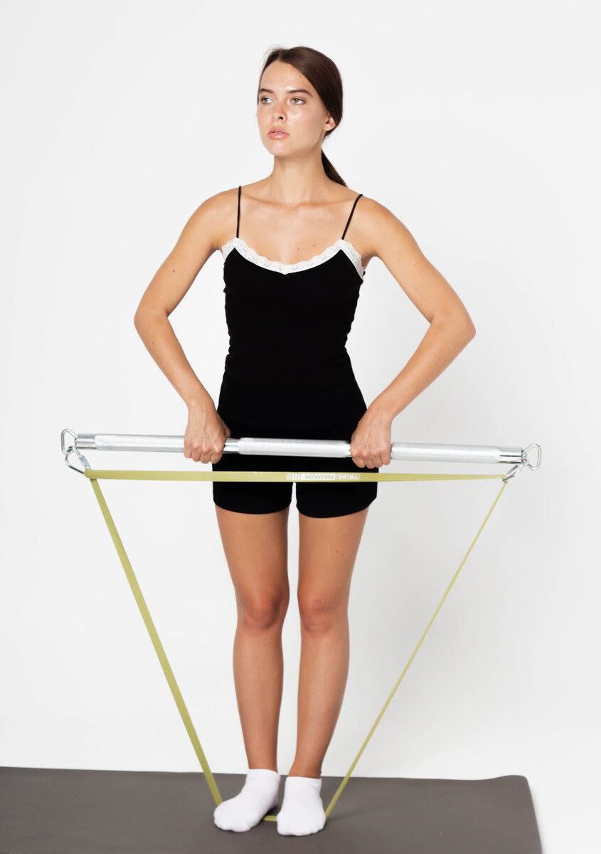Woman performing a standing resistance band exercise with an adjustable bar