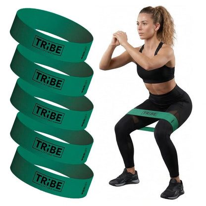 Woman demonstrating a squat with the green medium fabric resistance band from the Tribe Lifting resistance bands set of 5