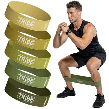 Man demonstrating a squat with the military green fabric resistance band from the Tribe Lifting resistance bands set of 5