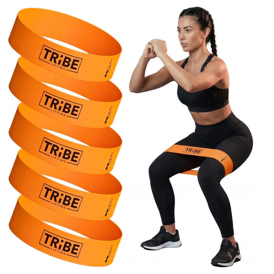 Woman demonstrating a squat with the orange light fabric resistance band from the Tribe Lifting resistance bands set of 5