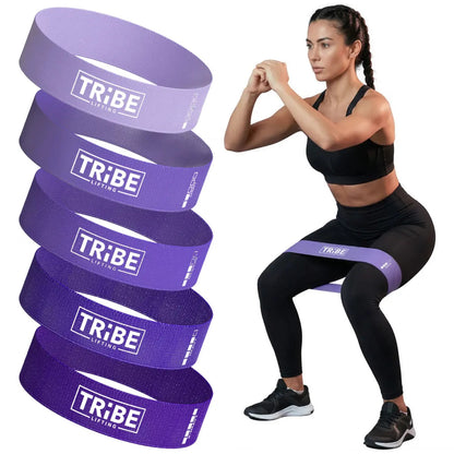 Woman demonstrating a squat with the purple fabric resistance band from the Tribe Lifting resistance bands set of 5