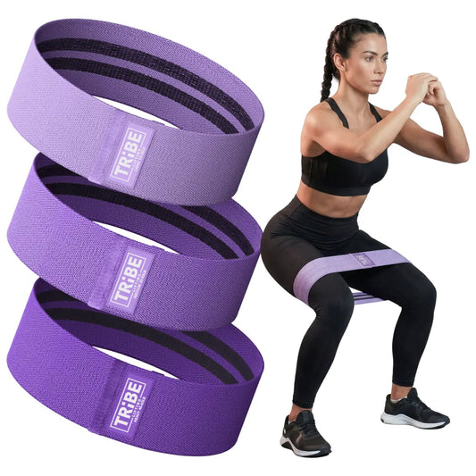 Woman demonstrating a squat with the Tribe Lifting purple premium resistance bands set 3