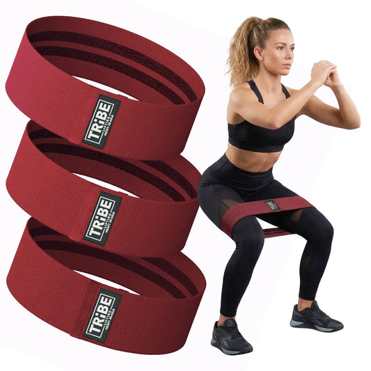 Woman demonstrating a squat with the Tribe Lifting red premium resistance bands set 3