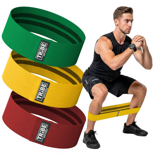 Man demonstrating a squat with the Tribe Lifting red yellow and green premium resistance bands set 3