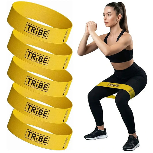 Woman demonstrating a squat with the yellow x-light fabric resistance band from the Tribe Lifting resistance bands set of 5